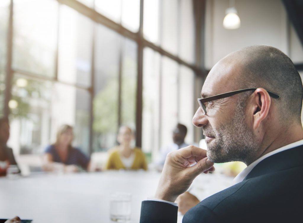 businessman in meeting, looking pensive